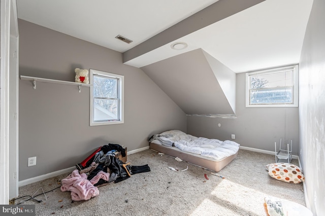 unfurnished bedroom featuring lofted ceiling, carpet floors, visible vents, and baseboards