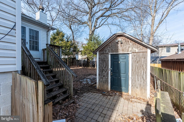 view of shed with stairs and fence