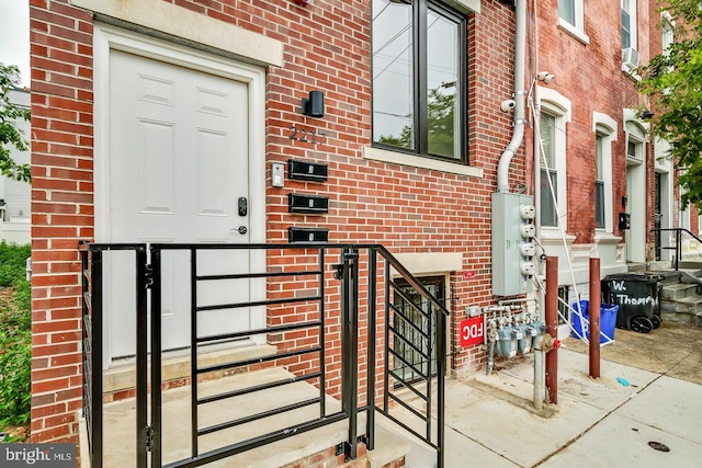 doorway to property featuring brick siding