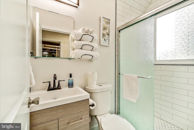 bathroom featuring tiled shower, vanity, and toilet