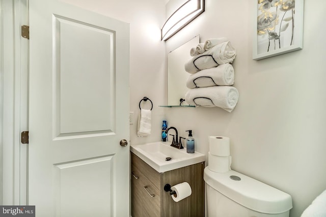 half bathroom with vanity and toilet