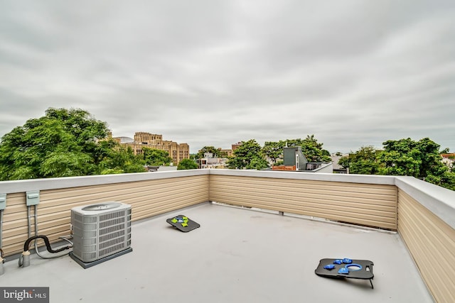 view of patio / terrace with a city view, a balcony, and central AC unit