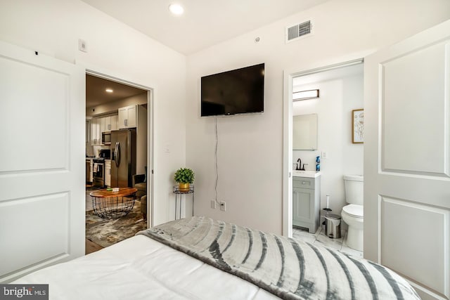 bedroom with recessed lighting, connected bathroom, visible vents, and stainless steel fridge with ice dispenser