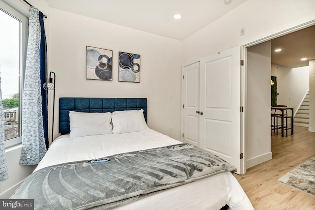 bedroom featuring baseboards, light wood finished floors, and recessed lighting