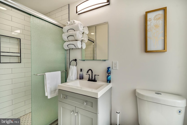 full bath with tiled shower, vanity, and toilet