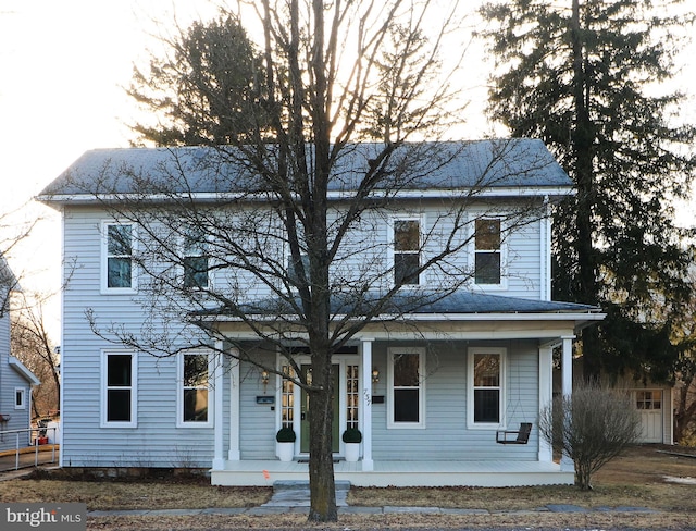 view of front of house featuring covered porch and fence