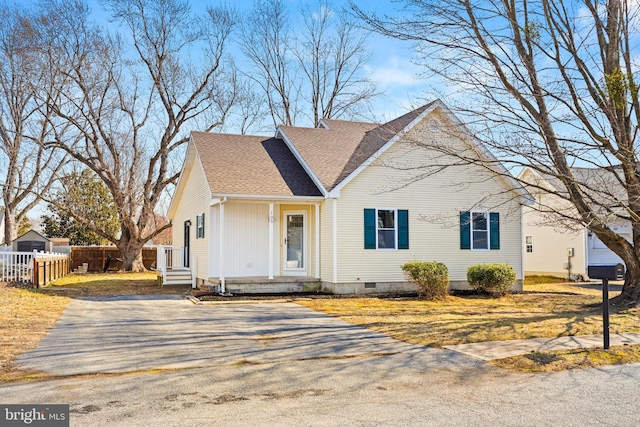 view of front facade with crawl space, a shingled roof, fence, and a front yard