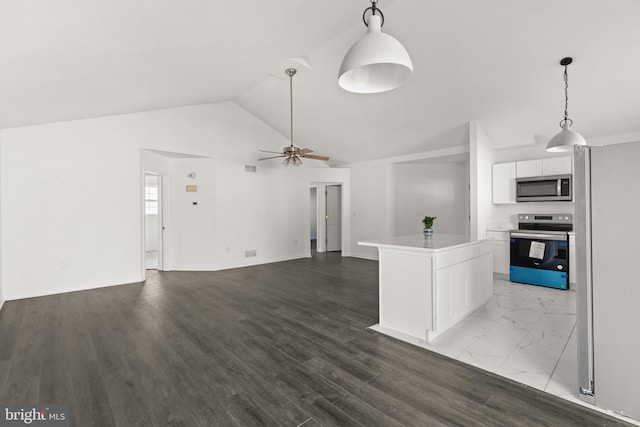 kitchen featuring light countertops, appliances with stainless steel finishes, a ceiling fan, white cabinets, and vaulted ceiling