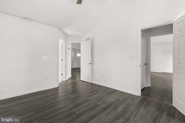 unfurnished bedroom with a ceiling fan, lofted ceiling, dark wood-style flooring, and baseboards