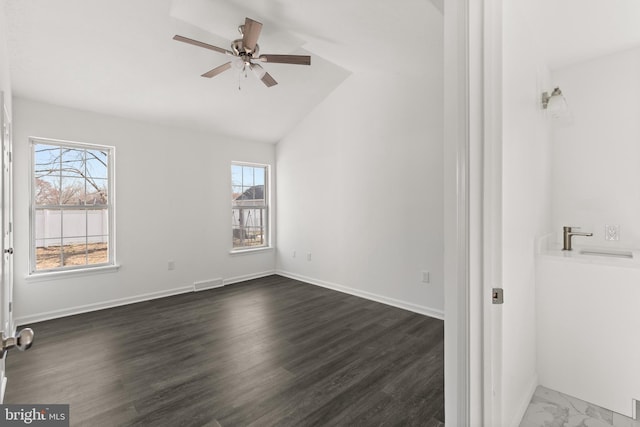 unfurnished bedroom featuring ceiling fan, visible vents, baseboards, vaulted ceiling, and dark wood-style floors