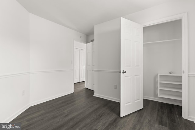 unfurnished bedroom with dark wood-type flooring and baseboards