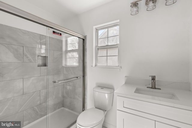 bathroom featuring vanity, a tile shower, and toilet