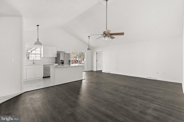 unfurnished living room with visible vents, ceiling fan, wood finished floors, high vaulted ceiling, and a sink