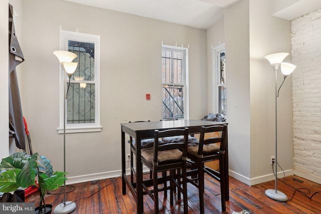 dining space with wood-type flooring, plenty of natural light, and baseboards