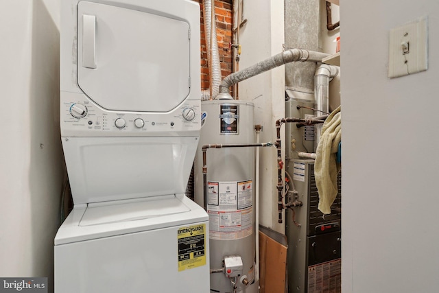 clothes washing area with stacked washing maching and dryer and gas water heater