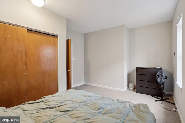 bedroom with carpet floors, baseboards, and a closet