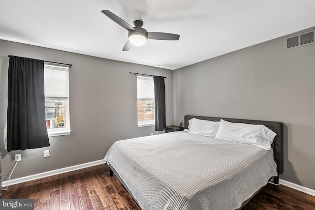 bedroom featuring ceiling fan, visible vents, baseboards, and hardwood / wood-style floors