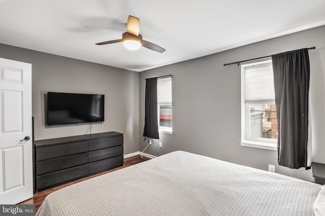 bedroom featuring dark wood-type flooring, baseboards, and ceiling fan