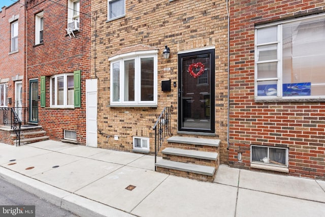 doorway to property featuring brick siding