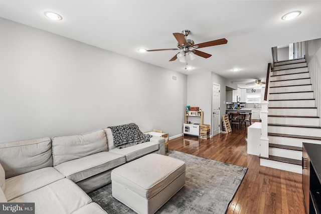 living area with recessed lighting, a ceiling fan, dark wood-style flooring, and stairs