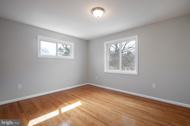 empty room featuring hardwood / wood-style flooring and baseboards