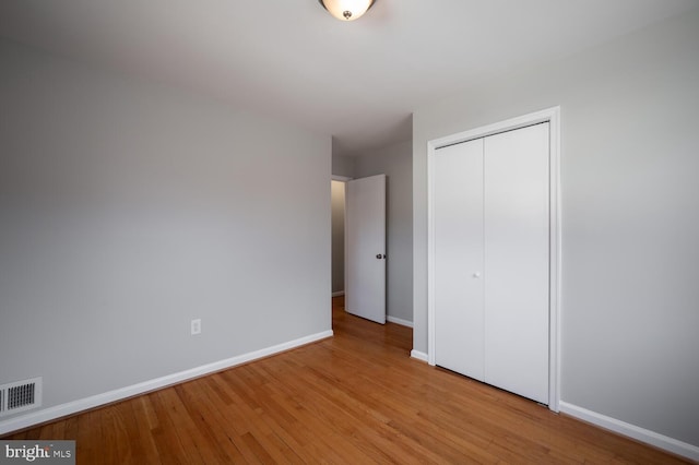 unfurnished bedroom featuring visible vents, baseboards, and wood finished floors