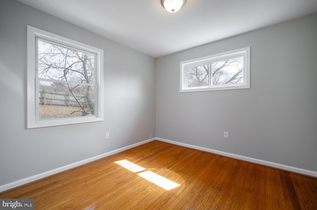 empty room with baseboards and wood finished floors