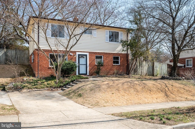 colonial house featuring brick siding and fence