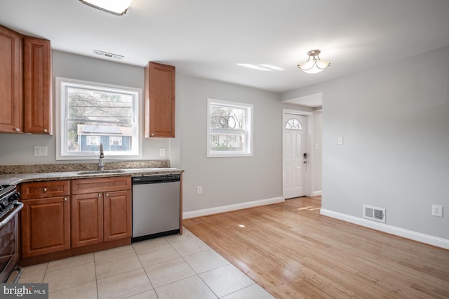 kitchen with stainless steel appliances, brown cabinets, visible vents, and a sink