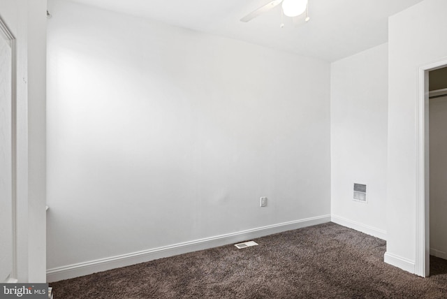 unfurnished bedroom with a ceiling fan, dark carpet, visible vents, and baseboards