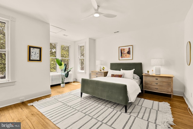 121 Kentucky Ave SE, Washington, DC 20003 - bedroom with radiator heating unit, multiple windows, wood finished floors, and a ceiling fan