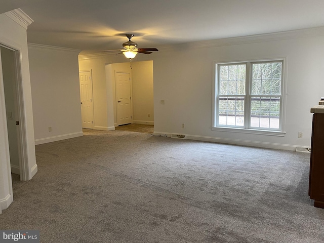 unfurnished living room with carpet floors, ornamental molding, a ceiling fan, and baseboards