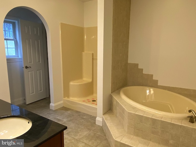 full bathroom featuring a garden tub, vanity, tile patterned flooring, baseboards, and walk in shower