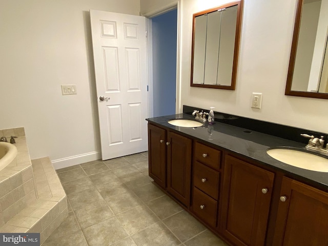 full bath featuring tiled tub, tile patterned floors, a sink, and double vanity