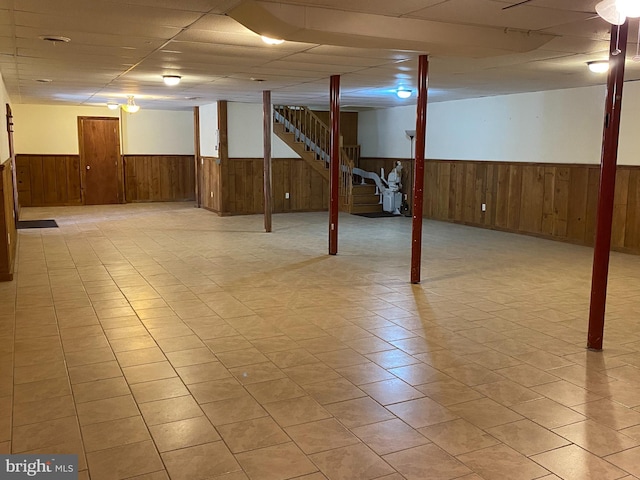 finished basement featuring a wainscoted wall and wood walls