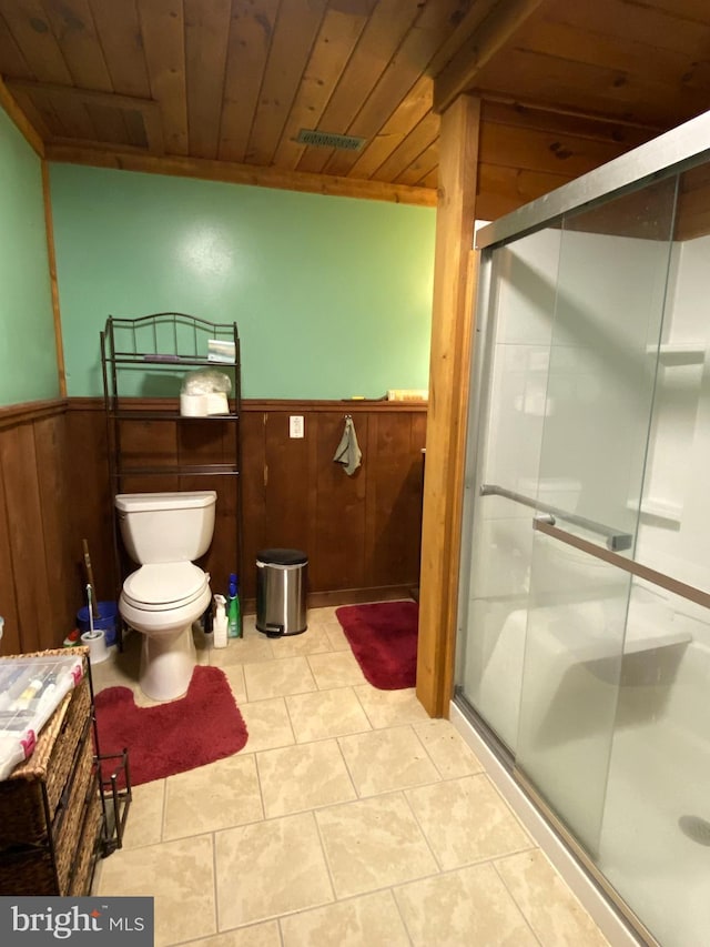 bathroom with a stall shower, wood ceiling, wainscoting, and wooden walls