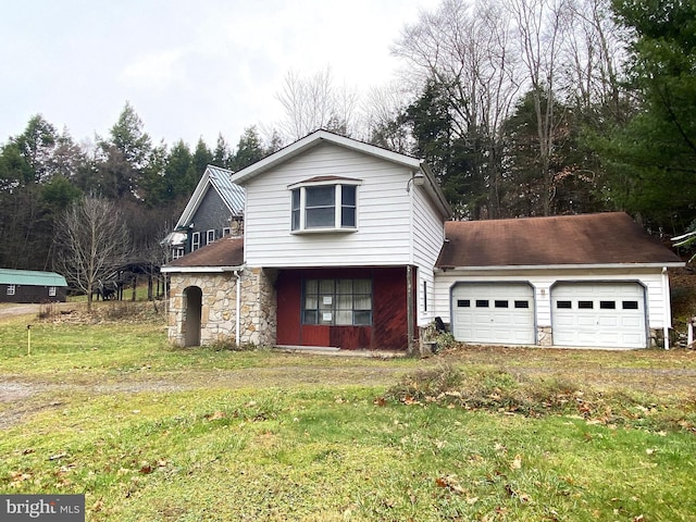 traditional-style home with a garage, a front yard, and stone siding