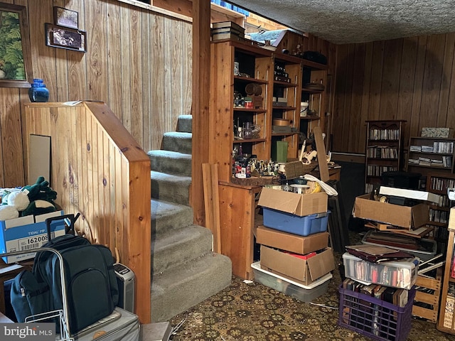 stairway featuring wooden walls and a textured ceiling