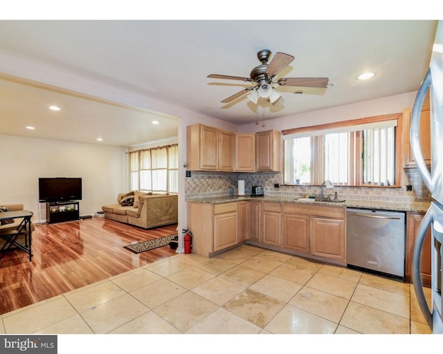 kitchen with light tile patterned floors, appliances with stainless steel finishes, backsplash, and a sink