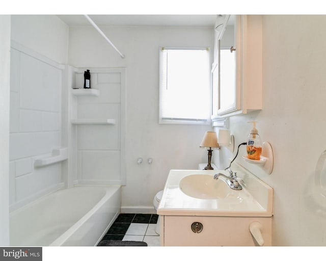 bathroom featuring bathing tub / shower combination, toilet, vanity, baseboards, and tile patterned floors