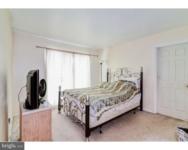 bedroom featuring baseboards and light colored carpet