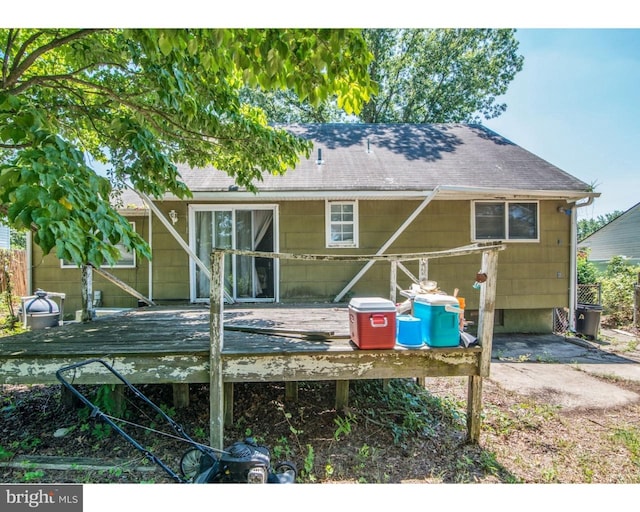 back of property featuring roof with shingles and a wooden deck