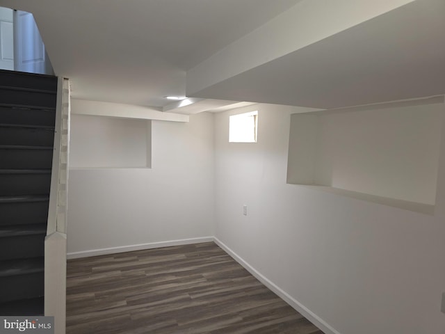 basement with stairway, baseboards, and dark wood-type flooring