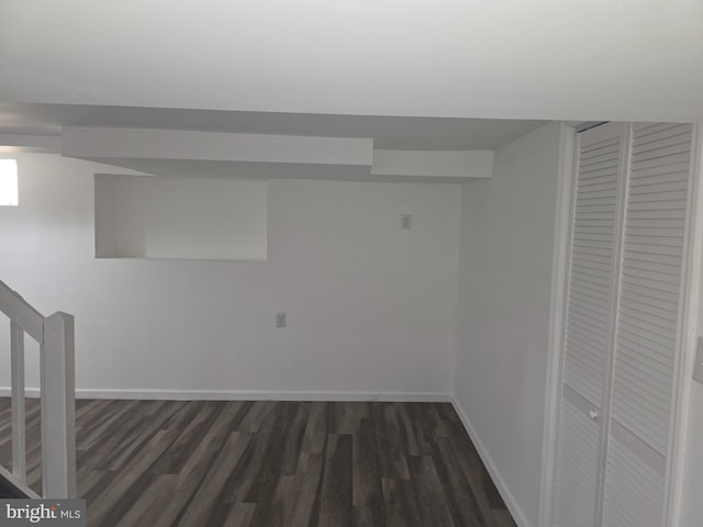 finished below grade area with dark wood-style floors and baseboards