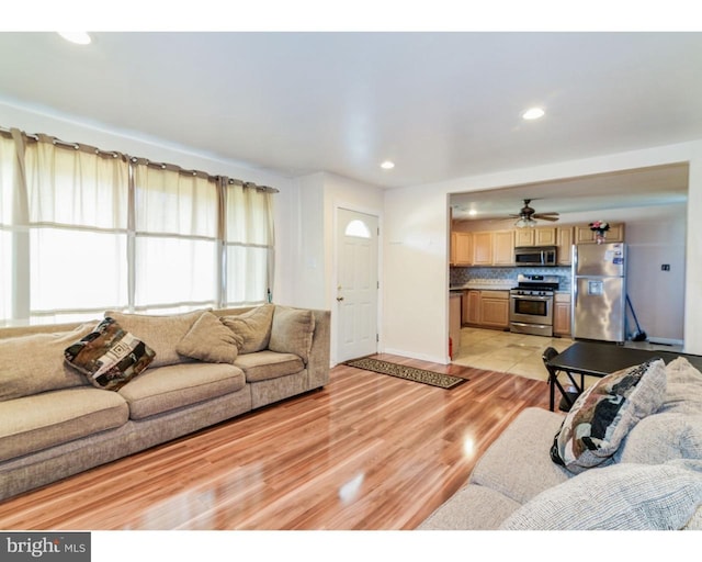 living room with a ceiling fan, recessed lighting, and light wood-style flooring