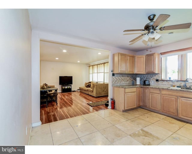 kitchen featuring light stone counters, light tile patterned flooring, a sink, light brown cabinetry, and tasteful backsplash