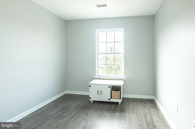 unfurnished room with dark wood-style floors, baseboards, and visible vents