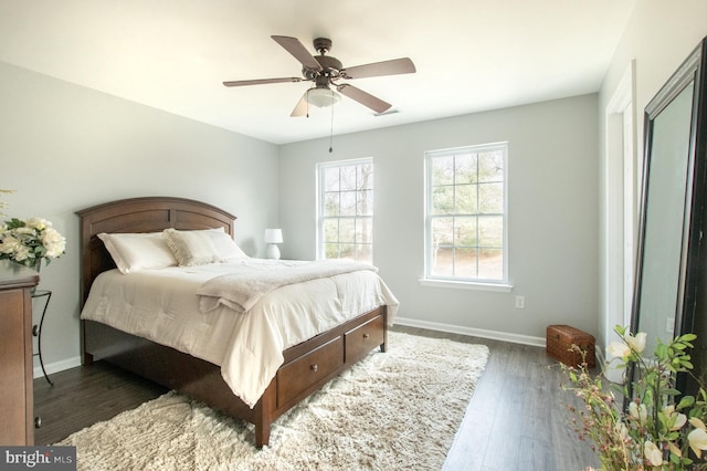 bedroom featuring a ceiling fan, baseboards, and wood finished floors