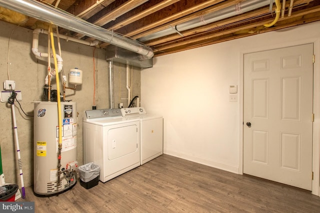 laundry room featuring laundry area, water heater, washer and dryer, and wood finished floors