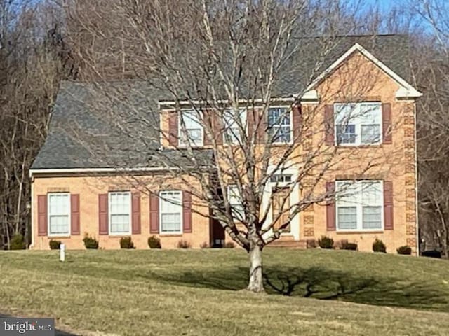 colonial home with a front lawn